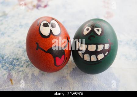 Les œufs de Pâques teignirent vert et brun avec des visages rires peints. Grimaces drôles avec les yeux, la langue et les grandes dents blanches. Visage effrayant pour Halloween. Émoticône Banque D'Images