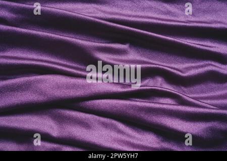 Tissu velours, semblable à la soie. Textiles dans des plis et de belles vagues. Tons violet, rose, magenta sur la drapery. Matériel de couture pour les soirées dres Banque D'Images