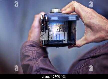 Capturer la beauté qui l'entoure. Un jeune homme prenant une photo avec son appareil photo Banque D'Images