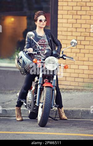 Elle fait de ce vélo un bon look. une jeune et élégante motard femme dehors Banque D'Images