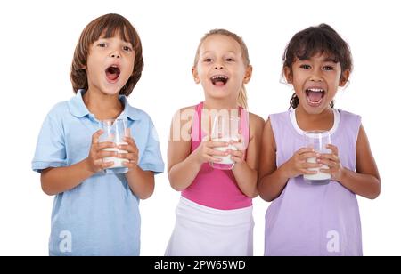 Plus de lait. Prise de vue en studio de trois jeunes enfants en train de rire lorsqu'ils boivent du lait Banque D'Images