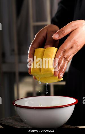 Préparation du tofu au lait jaune, nettoyage par le chef féminin Tahu Kuning Banque D'Images