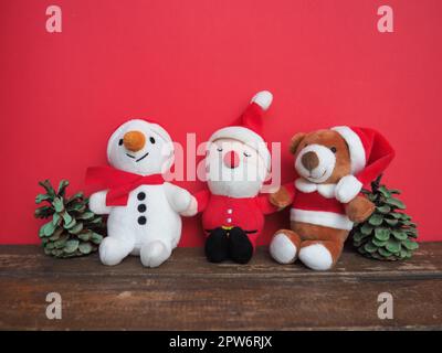 Peluches de Noël cousues sur fond rouge. Cônes peints. Un bonhomme de neige souriant, un cerf brun et un drôle de Père Noël. Saint-Sylvestre et CH Banque D'Images