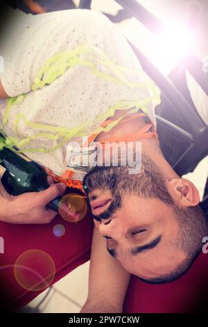 Faites la fête, buvez de l'alcool avec un homme qui dormait sur le sol après une fête du nouvel an ou un événement de clôture. Bière, sociale et fatiguée avec un homme endormi dans Banque D'Images