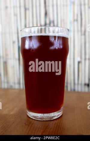 Verre de bière à la cerise sur la table du restaurant Banque D'Images