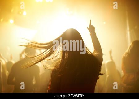 Danse, musique et dos de femme lors d'un concert, d'une soirée disco ou d'un festival de transe psychédélique. Nuit, énergie et femme dansant ou se déplaçant vers une chanson Banque D'Images