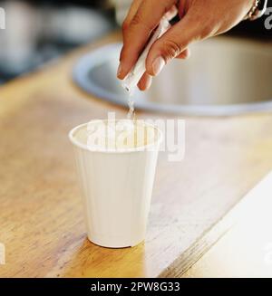 Le sucre, le café et les mains de personne dans le café pour le cappuccino, le restaurant et le shopping. Vente au détail, matin et espresso avec gros plan de l'homme et verser dans la tasse Banque D'Images