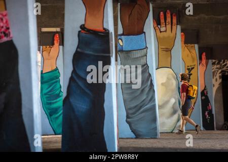 Pays-Bas, Eindhoven, zone de Strijp-S. Randonneur sous un passage supérieur avec graffiti sur les piliers, peint par l'artiste Niels Bakkerus. Banque D'Images