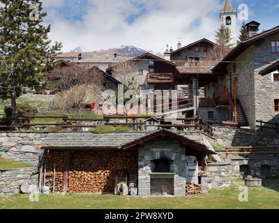 Maisons traditionnelles et pittoresques construites en pierre avec une pile de bois au premier plan dans la ville alpine de Lignan dans le Vally d'Aoste, au nord-ouest de l'Italie Banque D'Images