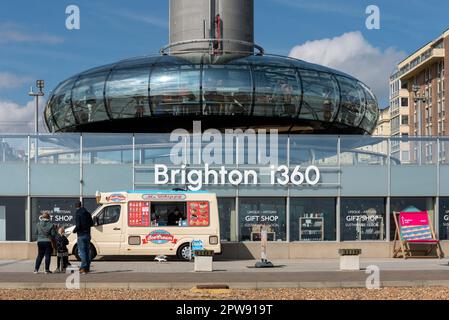 La tour d'observation Brighton i360 commence à s'élever avec le logo de l'entreprise devant elle, sous la surveillance d'une famille qui profite d'une journée passée à l'extérieur. Avril 2023 Banque D'Images