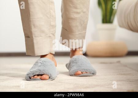 Femme portant des chaussons doux à la maison, gros plan Banque D'Images