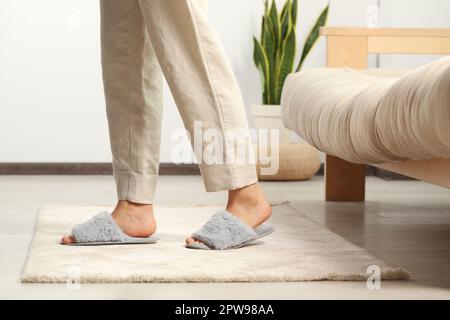 Femme portant des chaussons doux à la maison, gros plan Banque D'Images