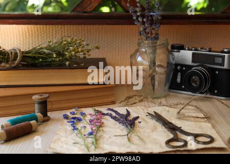 Composition avec de belles fleurs séchées et du papier sur une table en bois Banque D'Images