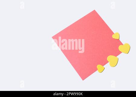 Note papier vierge avec petits coeurs jaunes sur fond blanc. Amour, mariage, Saint-Valentin. Banque D'Images