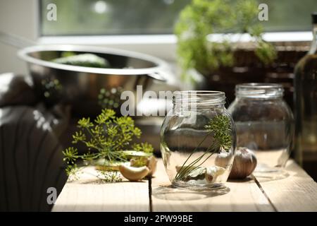 Vider les pots en verre et les ingrédients préparés pour la mise en conserve sur une table en bois à l'intérieur Banque D'Images