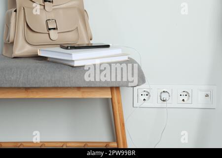 Prises électriques avec chargeur sur mur blanc Banque D'Images