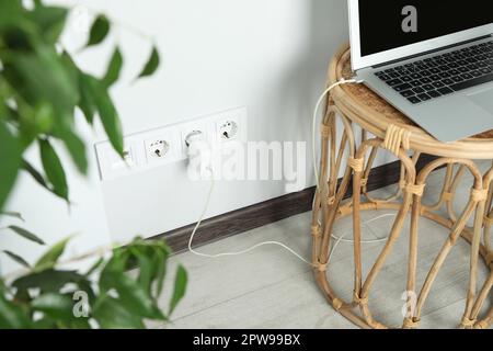 Prises électriques avec chargeur sur mur blanc Banque D'Images