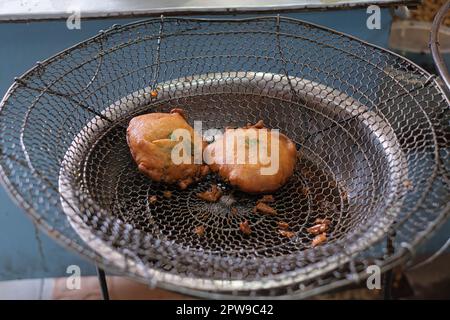 Les légumes indonésiens fritter ou OTE-OTE ou HECI sont sur le dessus d'une grille en treillis métallique pour sécher l'huile et il y a d'autres morceaux de nourriture éparpillés autour Banque D'Images