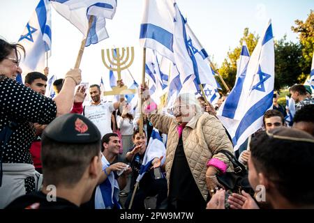 Israël. 27th avril 2023. Les jeunes partisans de la réforme religieuse s'agenouillent alors qu'ils applaudissent une femme de mère alors qu'elle danse et brandit le drapeau israélien à côté d'un symbole de la Menorah. Plus de 200 000 manifestent en faveur des gouvernements israéliens et c'est une révision juridique controversée devant la Knesset. Jérusalem, Israël. AVR 27th 2023. (Matan Golan/Sipa USA). Credit: SIPA USA/Alay Live News Banque D'Images