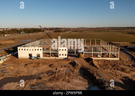 Photographie par drone d'un entrepôt construit par des ouvriers de la construction au cours de la matinée du printemps Banque D'Images