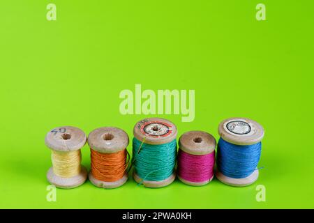 Vieux rouleaux de fil en bois sur fond vert Banque D'Images