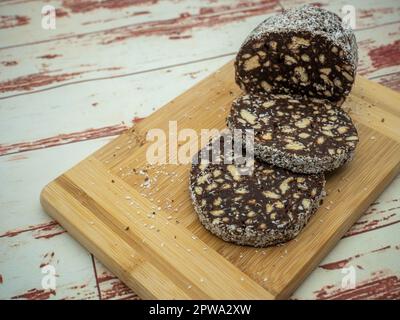 tranches de salami au chocolat avec biscuits sur une planche à découper Banque D'Images