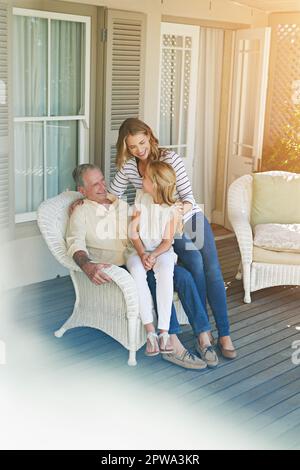 Passer du temps aux granpas. Photo pleine longueur d'une jeune fille assise à l'extérieur avec sa mère et son grand-père. Banque D'Images