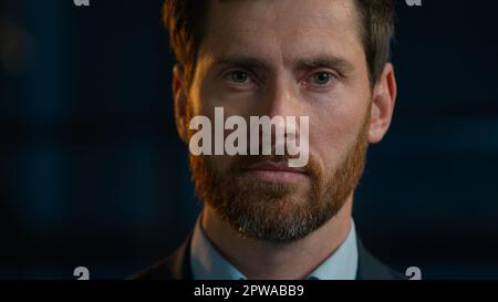 Portrait d'affaires homme caucasien sérieux homme adulte homme posant dans le bureau de soirée regardant la caméra gros plan visage triste âge moyen 40s barbu Banque D'Images