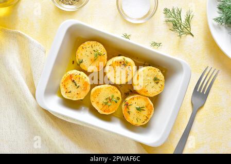 Pommes de terre au beurre cuites dans un plat de cuisson sur fond clair. Vue de dessus, plan d'agencement Banque D'Images