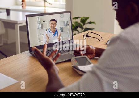 Homme souffrant d'hypertension ayant une consultation médicale avec un médecin en ligne sur ordinateur portable Banque D'Images
