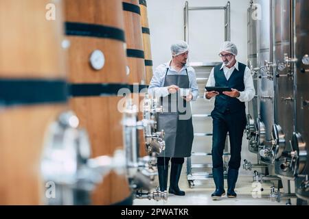 Viticulteur travaillant dans une grande usine moderne de vins alcool industrie de boisson qualité et contrôle de fermentation Banque D'Images