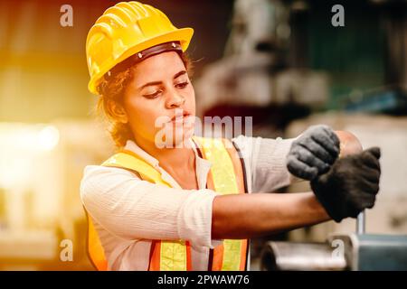 Femme afro-américaine travailleuse avec casque de sécurité travaillant dans l'industrie des métaux lourds usine travaillant dur femmes. Banque D'Images