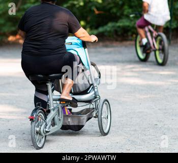 Femme à vélo avec son enfant sur un sentier dans le parc national de Belmont Lake. Banque D'Images