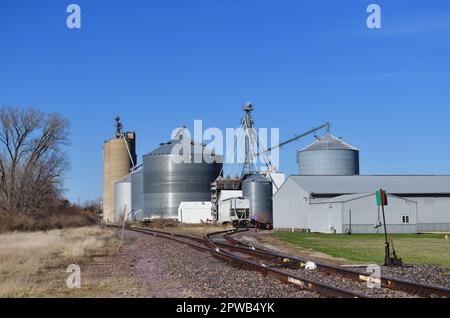 Earlville, Illinois, États-Unis. Silos à grains dans un complexe de coopératives agricoles à côté d'une ligne de chemin de fer dans une petite communauté du centre-nord de l'Illinois. Banque D'Images