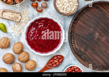 vue de dessus assiette ronde en bois avec des œufs en gelée différentes noix et graines sur fond blanc pâte sucre biscuit doux noix photo gâteau Banque D'Images