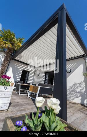 éco-respectueux bioclimatique aluminium pergola structure d'ombre, auvent et terrasse toit, salon de jardin, chaises, barbecue en métal entouré par l'aménagement paysager Banque D'Images