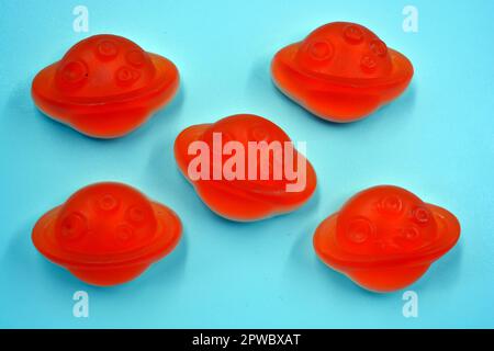Bonbons colorés et colorés pour enfants en gelée, bonbons sous forme de planètes orange, astéroïde, jupiter situé sur un fond blanc. Banque D'Images