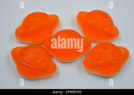 Bonbons colorés et colorés pour enfants en gelée, bonbons sous forme de planètes orange, astéroïde, jupiter situé sur un fond blanc. Banque D'Images