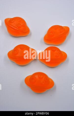 Bonbons colorés et colorés pour enfants en gelée, bonbons sous forme de planètes orange, astéroïde, jupiter situé sur un fond blanc. Banque D'Images