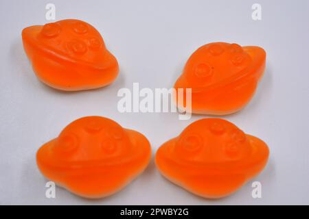 Bonbons colorés et colorés pour enfants en gelée, bonbons sous forme de planètes orange, astéroïde, jupiter situé sur un fond blanc. Banque D'Images