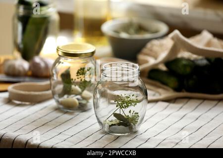 Vider les pots en verre et les ingrédients préparés pour être mis en conserve sur la table Banque D'Images