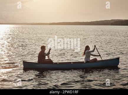 Il s'agit de ramer le bateau n'atteignant pas la destination. un jeune couple aviron un bateau sur le lac. Banque D'Images