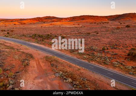 Vue aérienne d'une autoroute traversant un paysage désertique à Broken Hill dans l'Outback de la Nouvelle-Galles du Sud en Australie Banque D'Images
