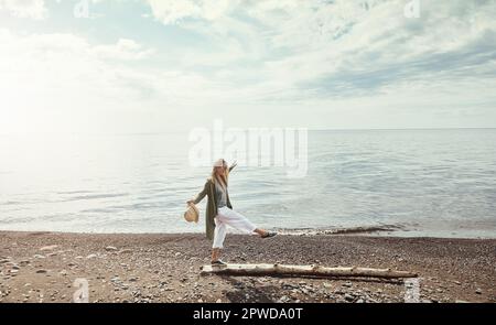 Theres aucun moyen de s'ennuyer dans la nature. une jeune femme marchant le long d'une bûche à un lac. Banque D'Images