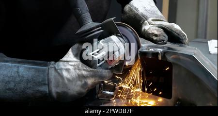 Vue des mains d'un ouvrier meulant un morceau de métal, France Banque D'Images