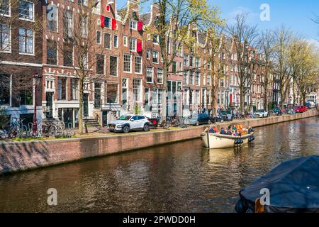 AMSTERDAM, HOLLANDE - 17 AVRIL 2023 : les Toursts profitent d'une excursion en bateau le long d'un canal à Amsterdam, capitale des pays-Bas Banque D'Images
