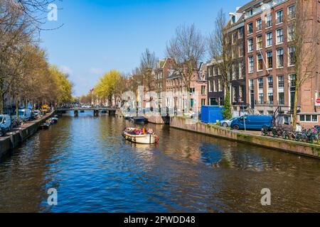 AMSTERDAM, HOLLANDE - 17 AVRIL 2023 : les Toursts profitent d'une excursion en bateau le long d'un canal à Amsterdam, capitale des pays-Bas Banque D'Images
