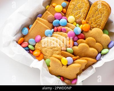 Assortiment de biscuits et bonbons dans le panier. Concept de la Fête des mères. Forfait soin fait main, boîte cadeau saisonnière avec bonbons, dragee et biscuits pour la famille, Banque D'Images