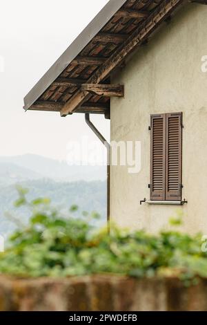 Vue panoramique sur les collines depuis une ancienne maison avec toit en bois et fenêtre dans le château de San Sebastiano da po, Turin, région du Piémont, Italie, verticale Banque D'Images