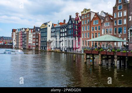 AMSTERDAM, HOLLANDE - 18 AVRIL 2023 : des maisons hollandaises typiques bordent un canal dans la capitale des pays-Bas, connue pour son patrimoine artistique, son système de canaux élaboré Banque D'Images